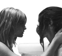 a black and white photo of two women in a bathtub